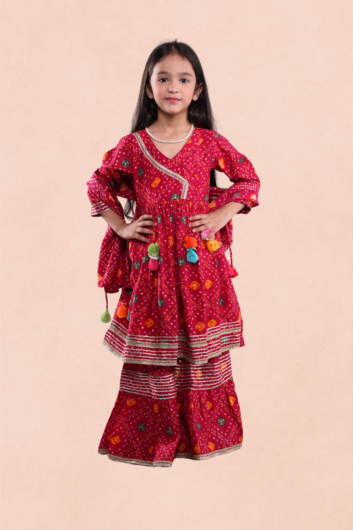 Young girl wearing a red traditional outfit with patterns on a beige background