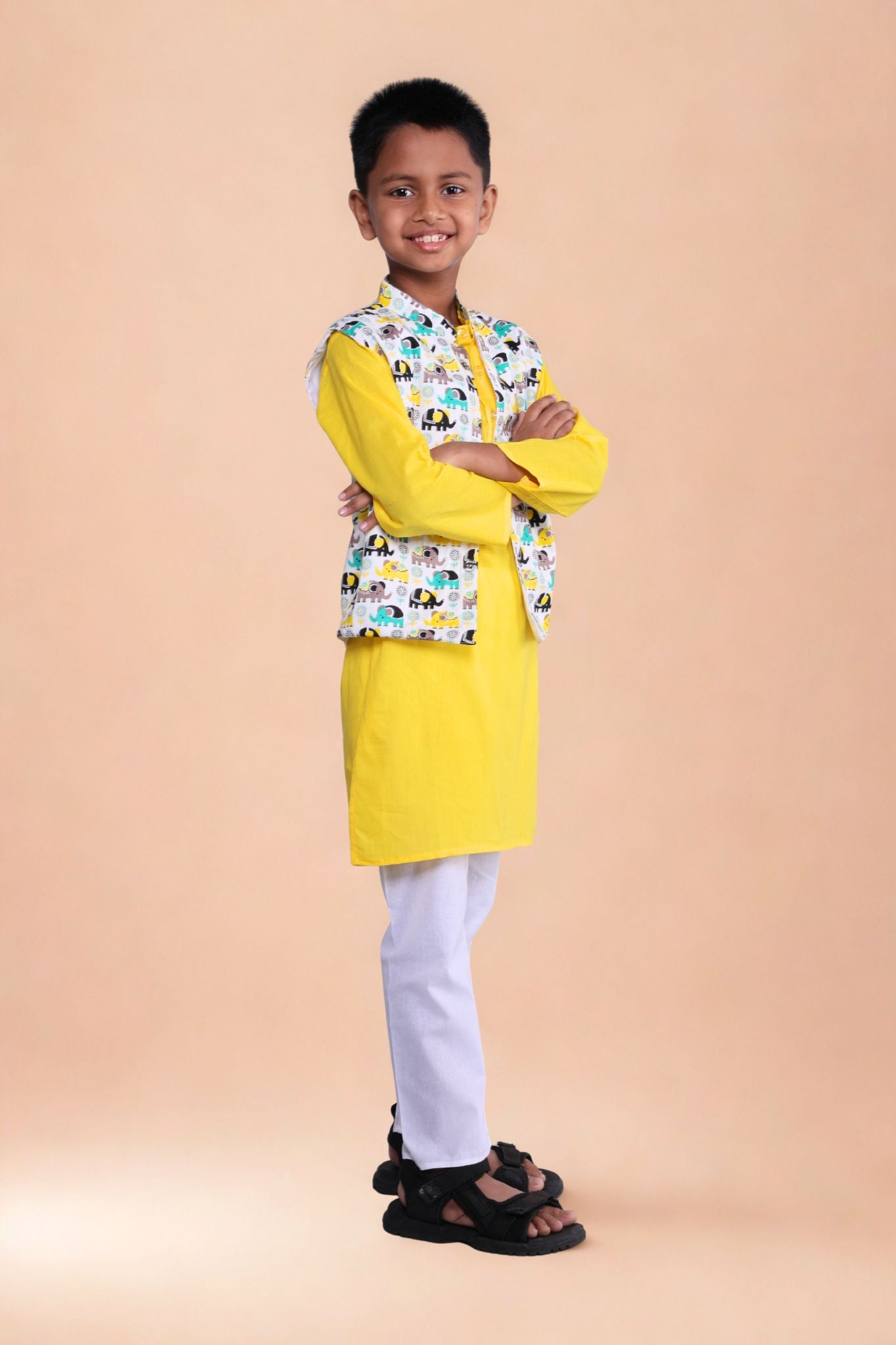 Child wearing a yellow kurta with a patterned shirt on a beige background