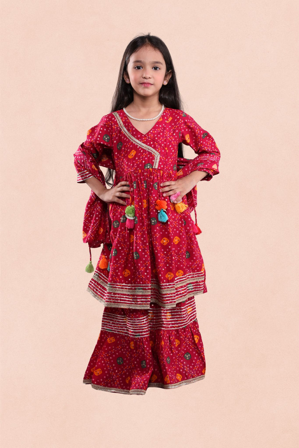 Young girl wearing a red traditional outfit with patterns on a beige background